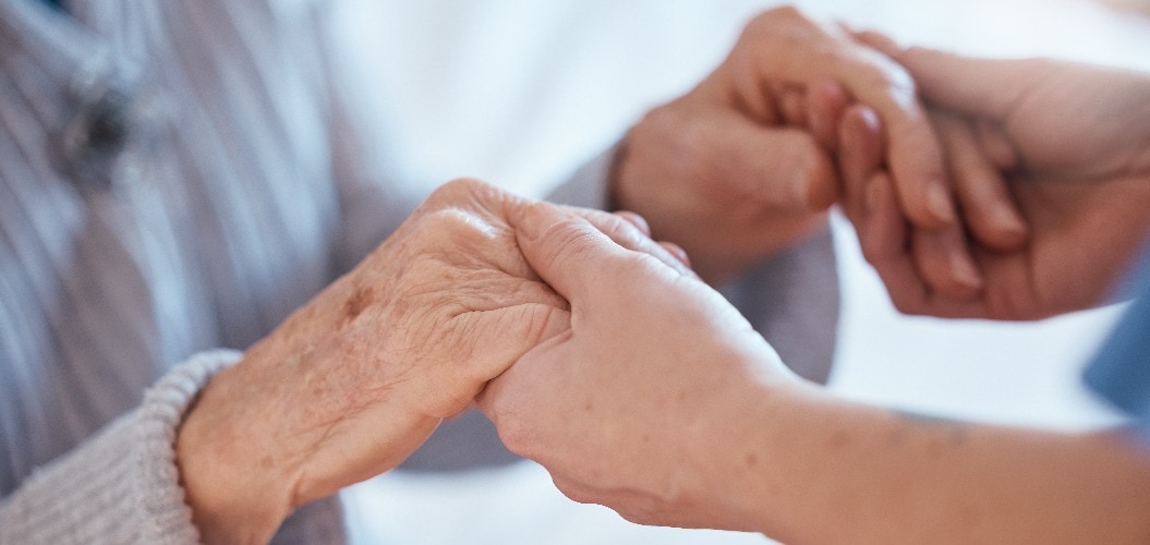 Elderly woman hands, support and holding healthcare worker for medical care or help walking. Retirement care, senior person and holding hands for volunteer caregiver service in health community